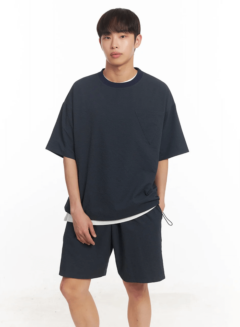 Model wearing men's adjustable wide-fit shorts and matching oversized tee in navy blue, perfect for casual lounge wear.